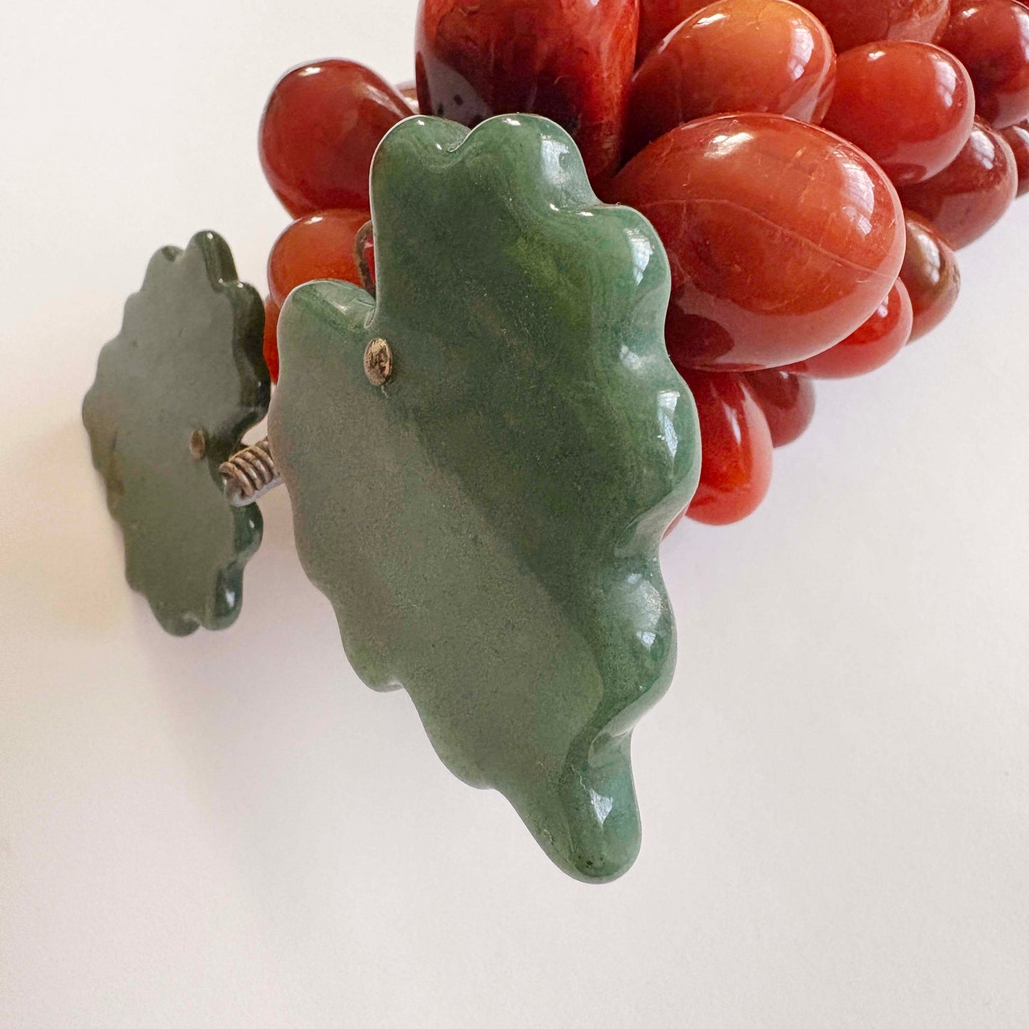 Green leaf-shaped with red grapes on a white background