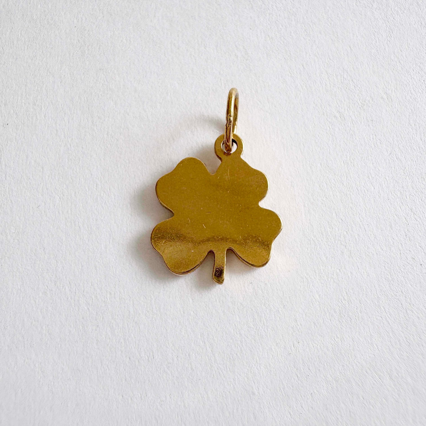 Gold four-leaf clover pendant on a white background