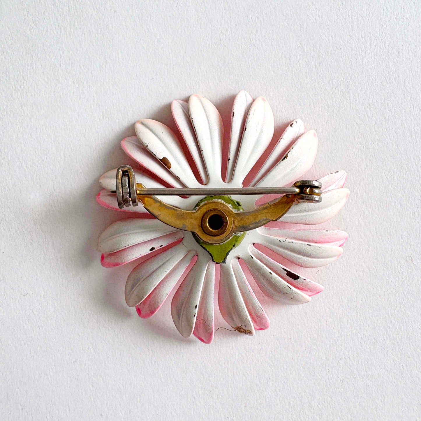 Floral brooch with white and pink petals on a light gray background