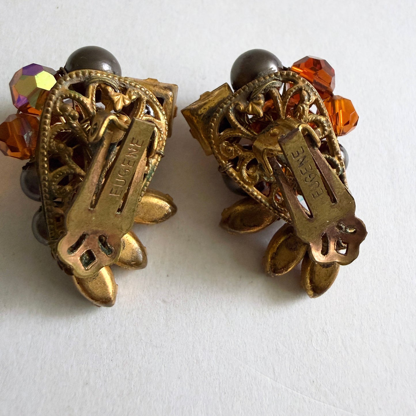 Detailed view of the reverse side of Eugene earrings showing the intricate gold-tone hand-wired filigree construction and tension clip-on mechanisms.