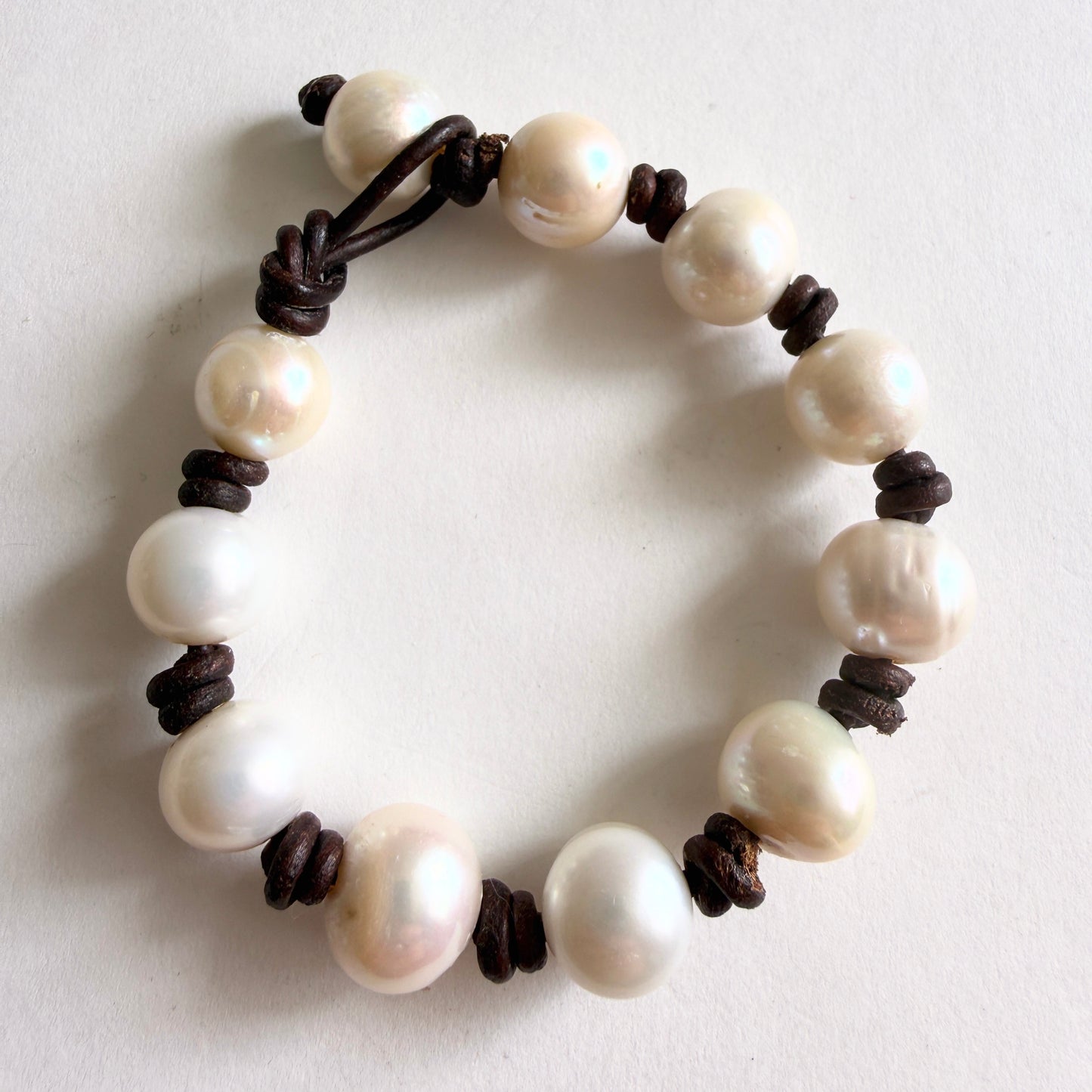 Detailed view of the integrated pearl-and-loop toggle clasp, showcasing the seamless and organic construction.