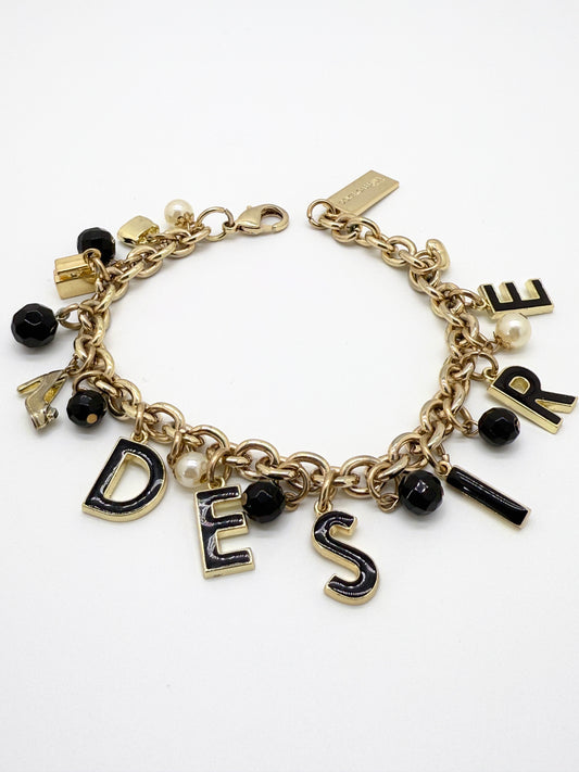Bracelet with letter charms spelling 'DESIRE' on a white background