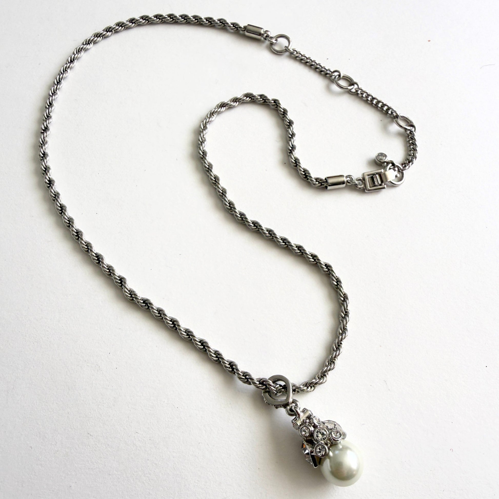 Silver necklace with a pearl pendant on a white background