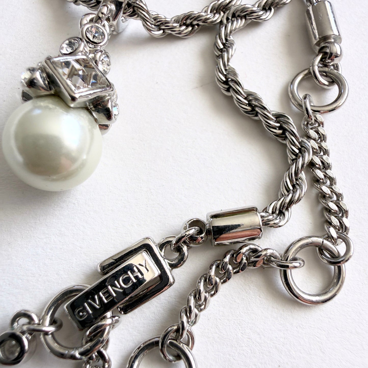 Silver chain necklace with Givenchy clasp on a white background