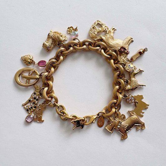 Vintage Kirk’s Folly gold-tone dog charm bracelet with rhinestones and whimsical charms on white background