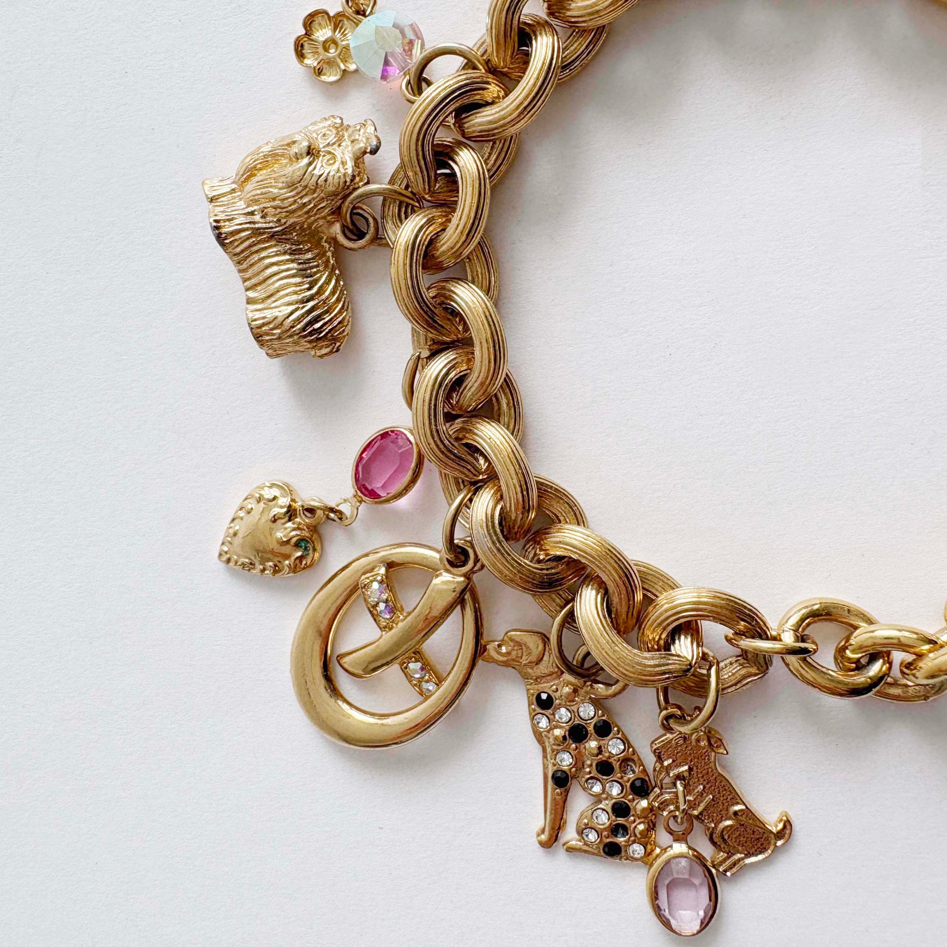 Vintage Kirk’s Folly gold-tone dog charm bracelet with rhinestones and whimsical charms on white background