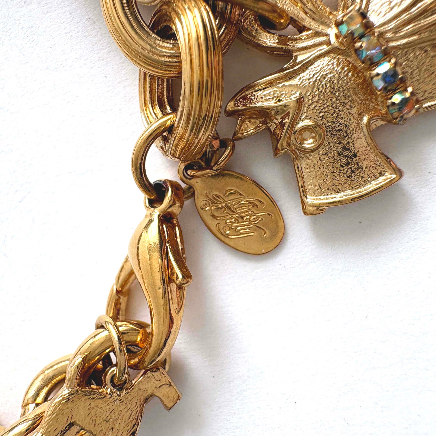 Vintage Kirk’s Folly gold-tone dog charm bracelet with rhinestones and whimsical charms on white background