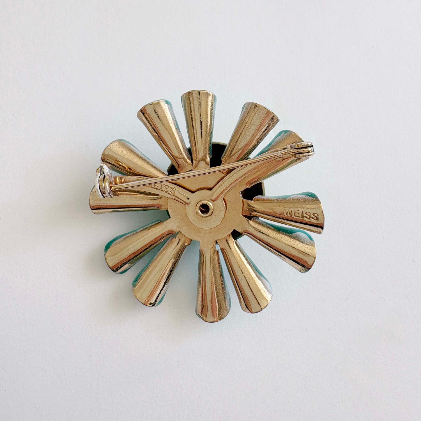 Gold-colored metal propeller-like object on a white background