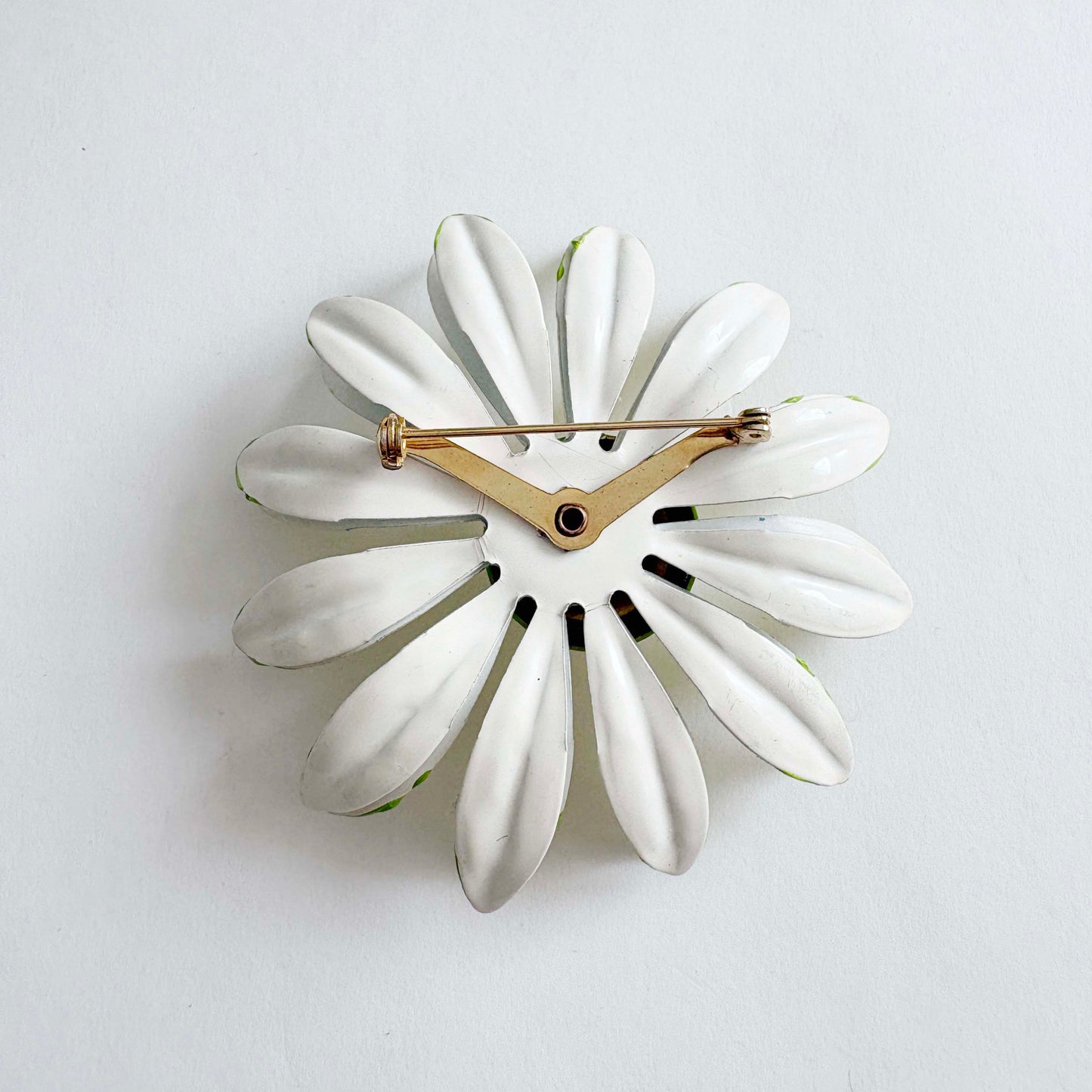 White wall clock with a floral design on a light gray background