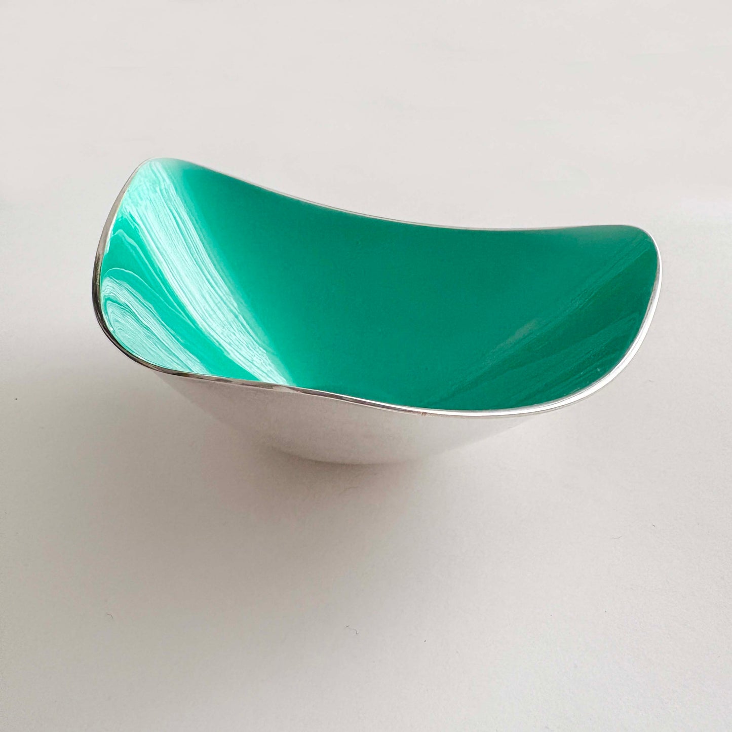 Teal and silver bowl light gray background