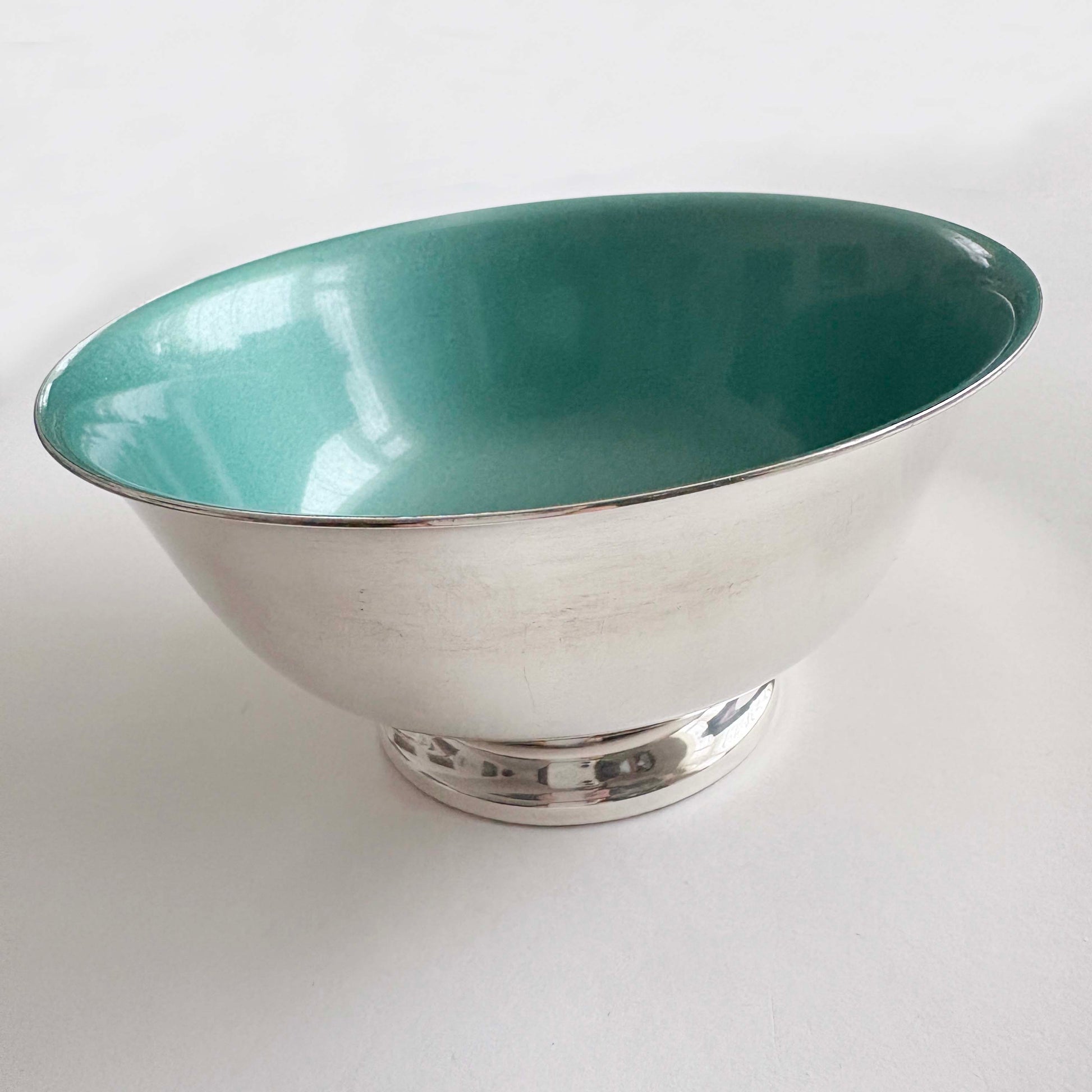 Teal and silver bowl on a white background