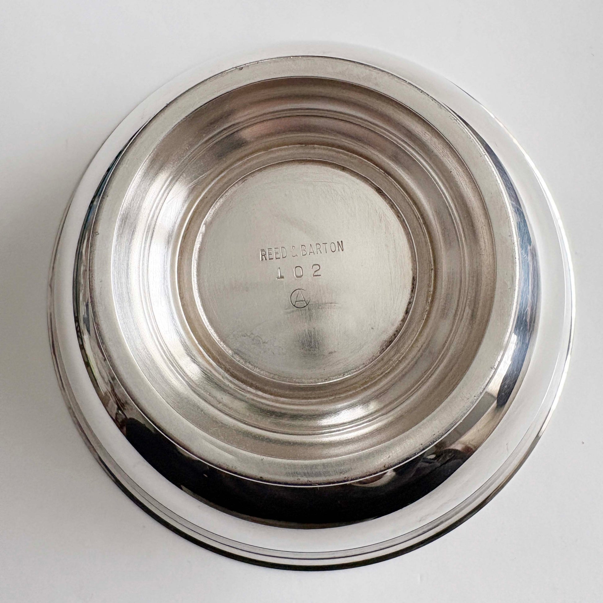 Silver bowl with 'Reed & Barton' engraving on a white background