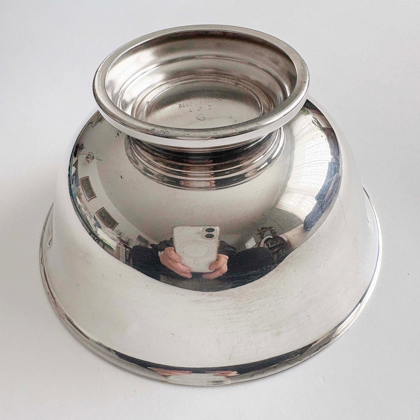 Silver bowl with reflective surface on a white background