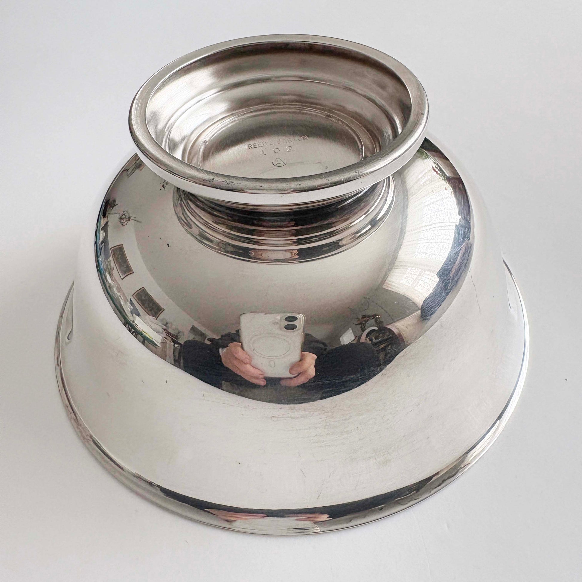 Silver bowl with reflective surface on a white background