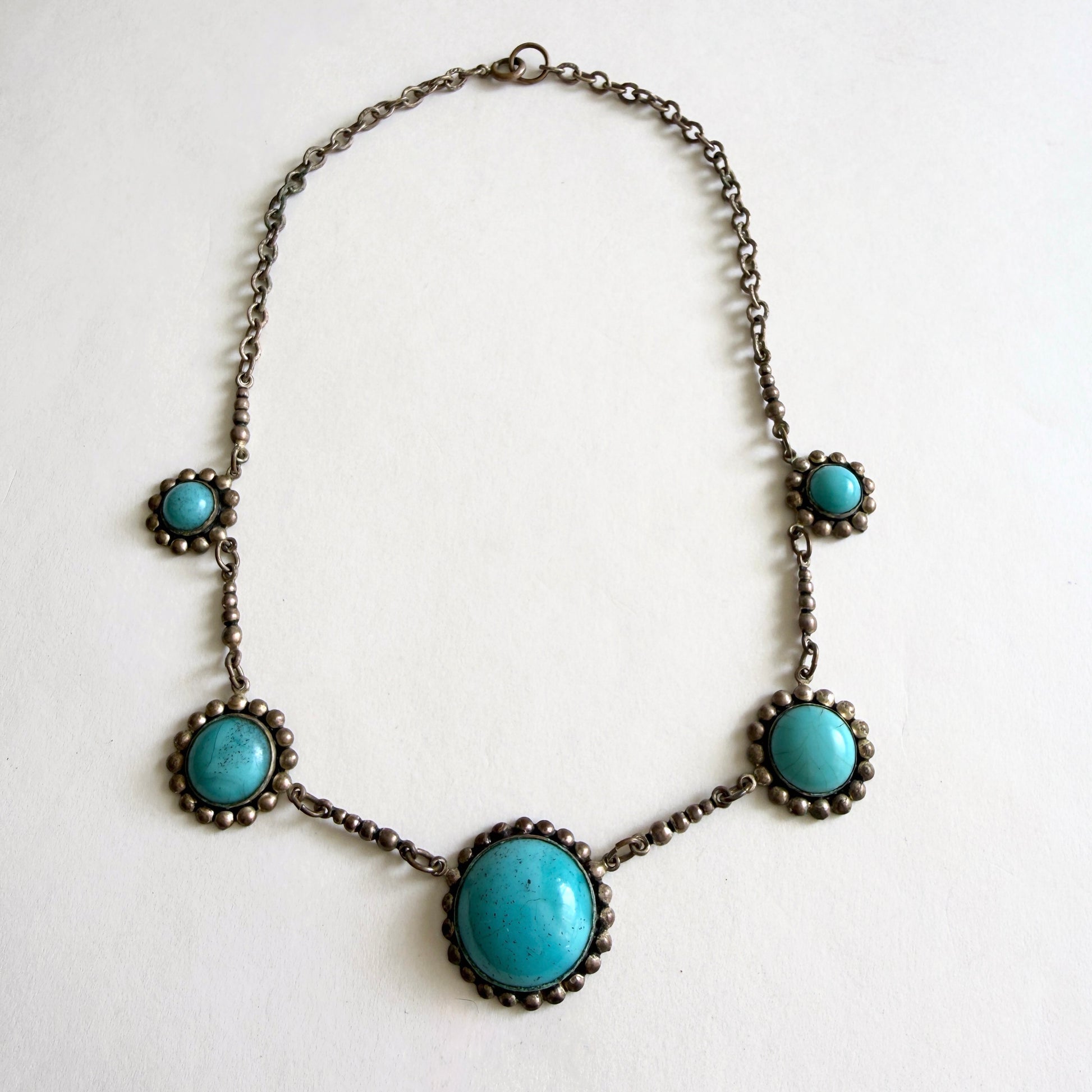 Vintage Czech turquoise glass cabochon necklace with five molded glass stones set in aged silver tone metal with brass patina.