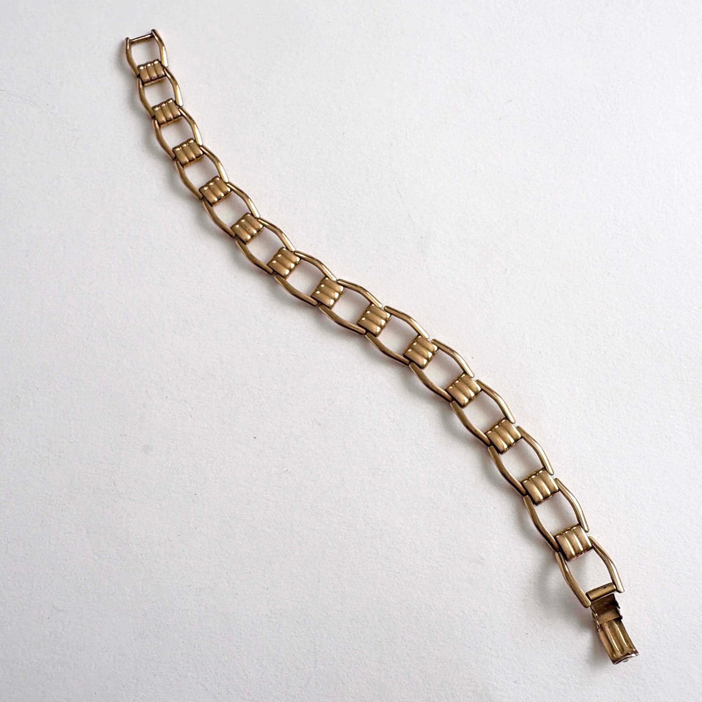 Kreisler gold tone chain bracelet on a white background