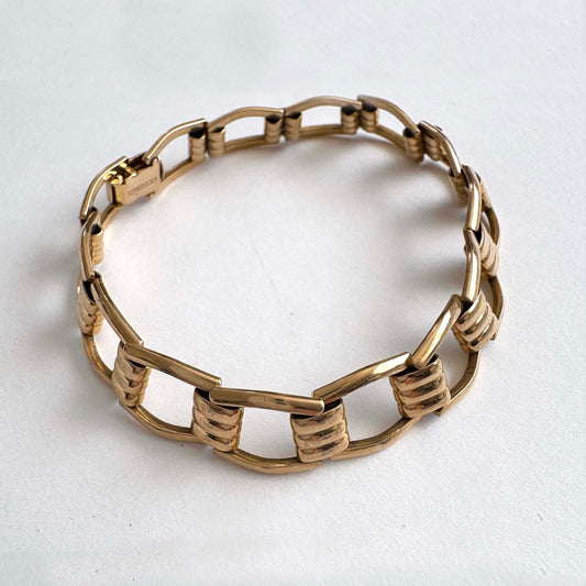 Kreisler gold tone bracelet on a light gray background