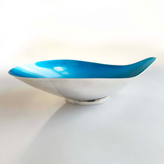 Decorative bowl with blue top and silver base on a light background