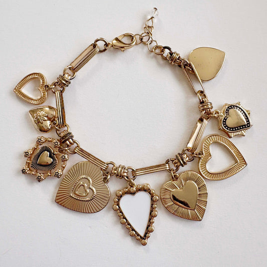 Gold bracelet with heart-shaped charms on a white background