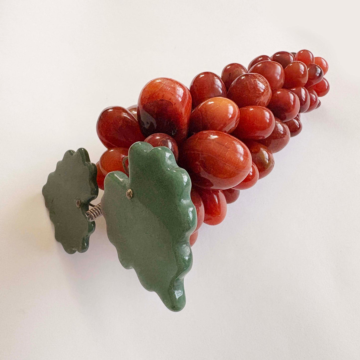  red grapes and a green leaves on a white background