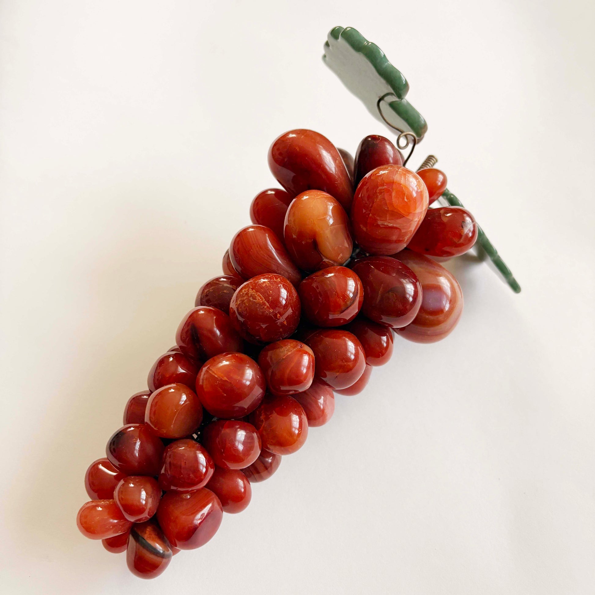 red grape bunch with a green stem on a white background
