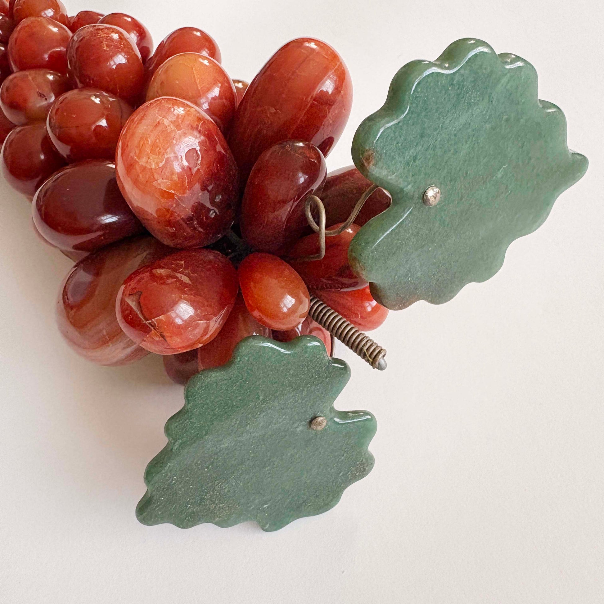Decorative red grapes and green leaves on a white background