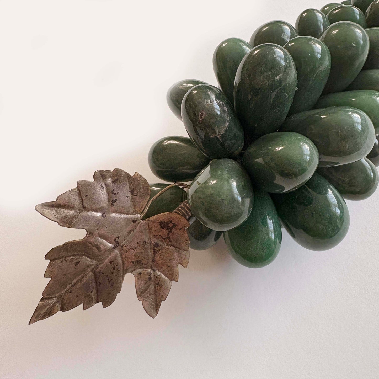 Green stone grapes with a leaf on a white background