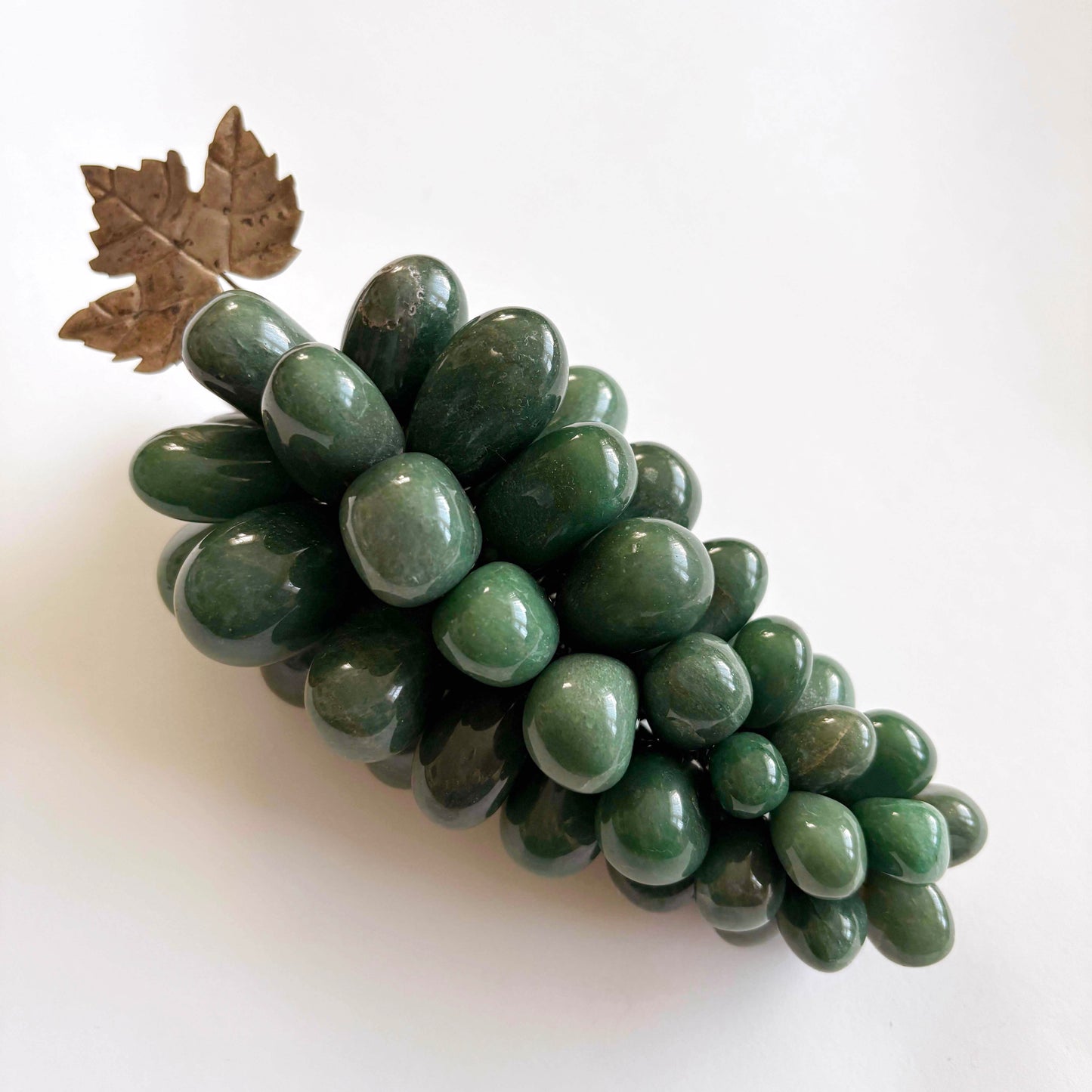 Green stone grapes with a leaf on a white background