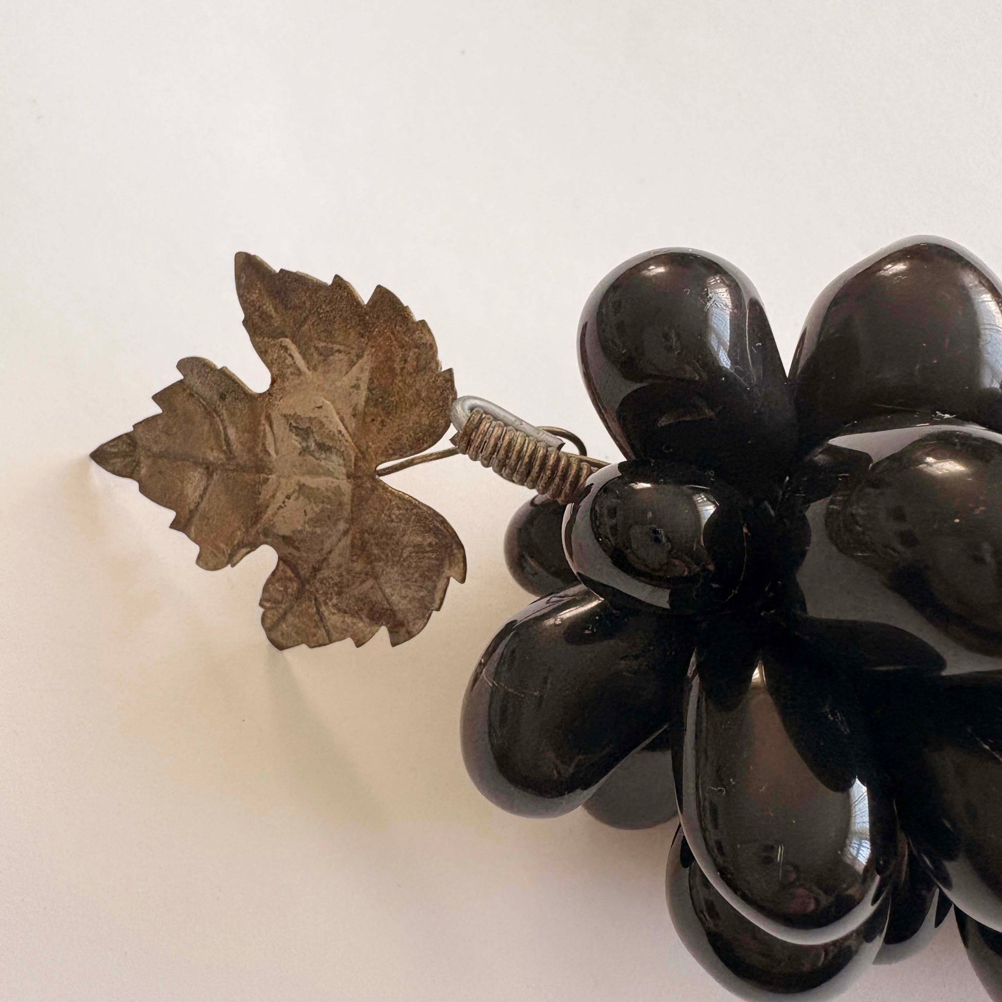 Black grapes with a leaf detail on a white background