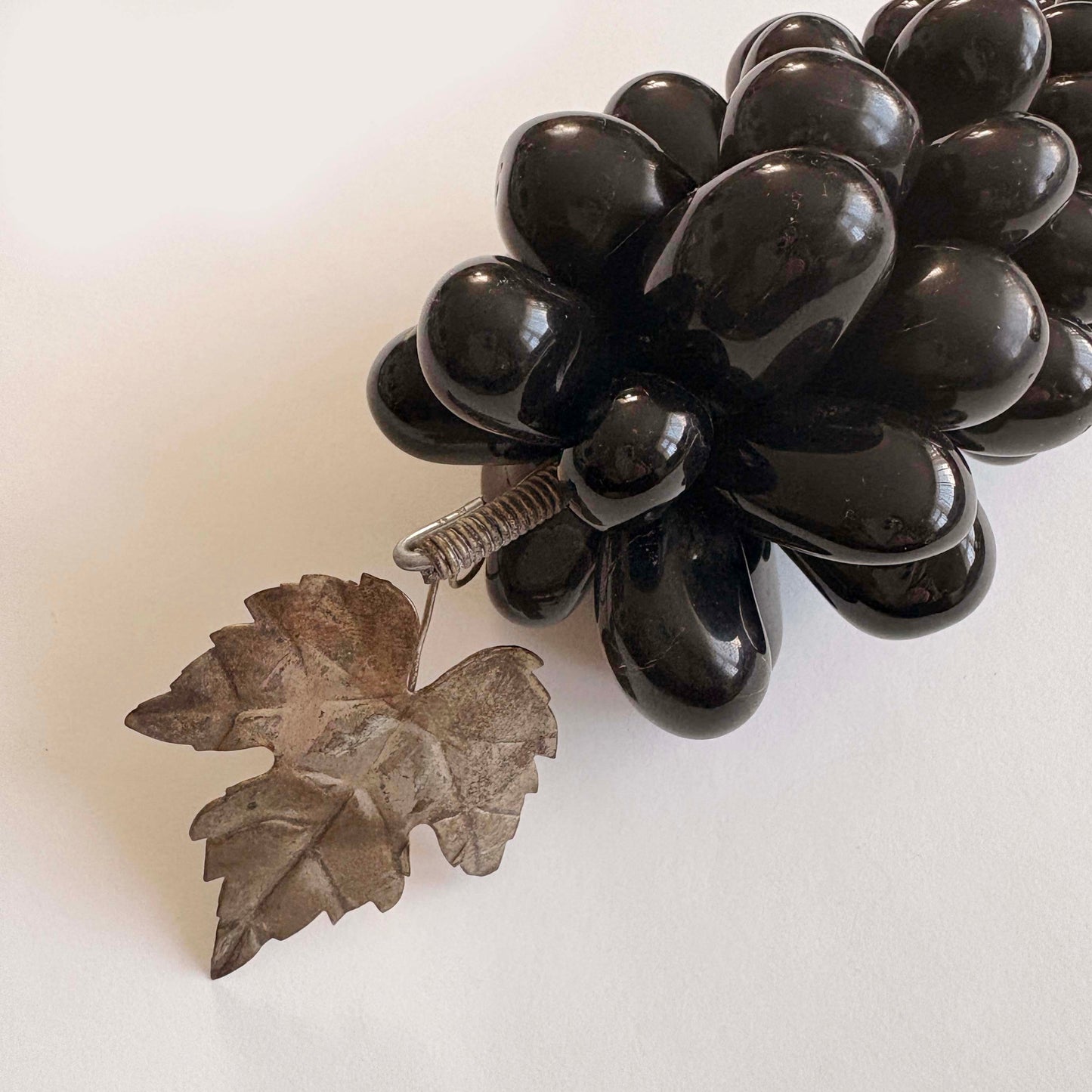 Black stone grapes with a leaf design on a white background