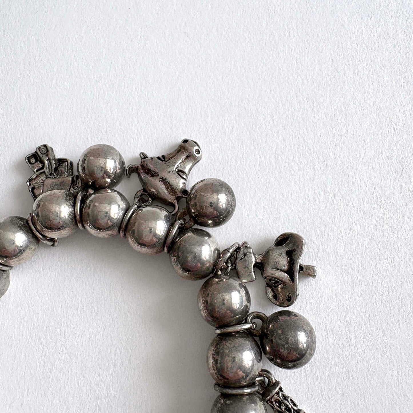 Silver tone beaded bracelet with southwestern charms and beads on a white background