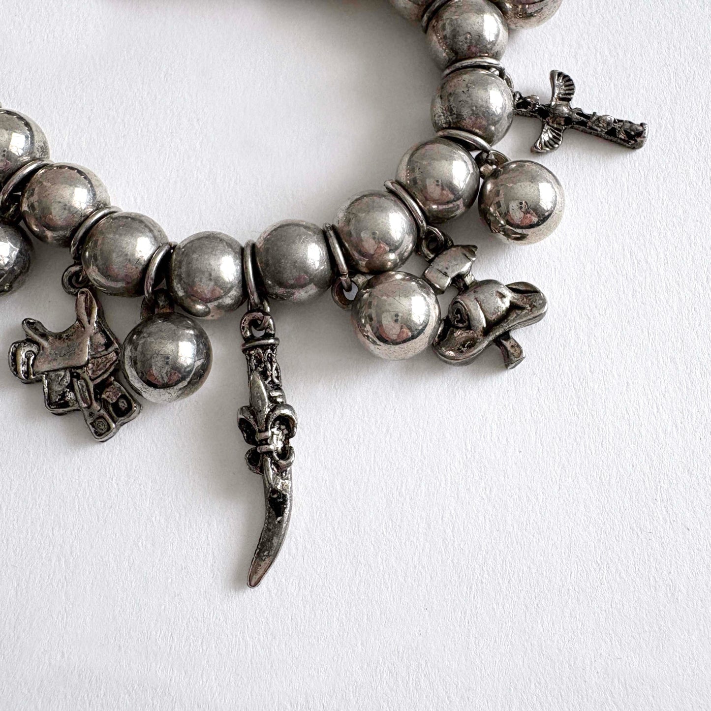 Silver tone beaded bracelet with southwestern charms and beads on a white background