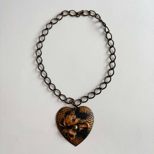 Vintage 1950s hammered copper heart pendant necklace with sculptural leaf motif on chunky copper chain, mid-century modern artisan jewelry.