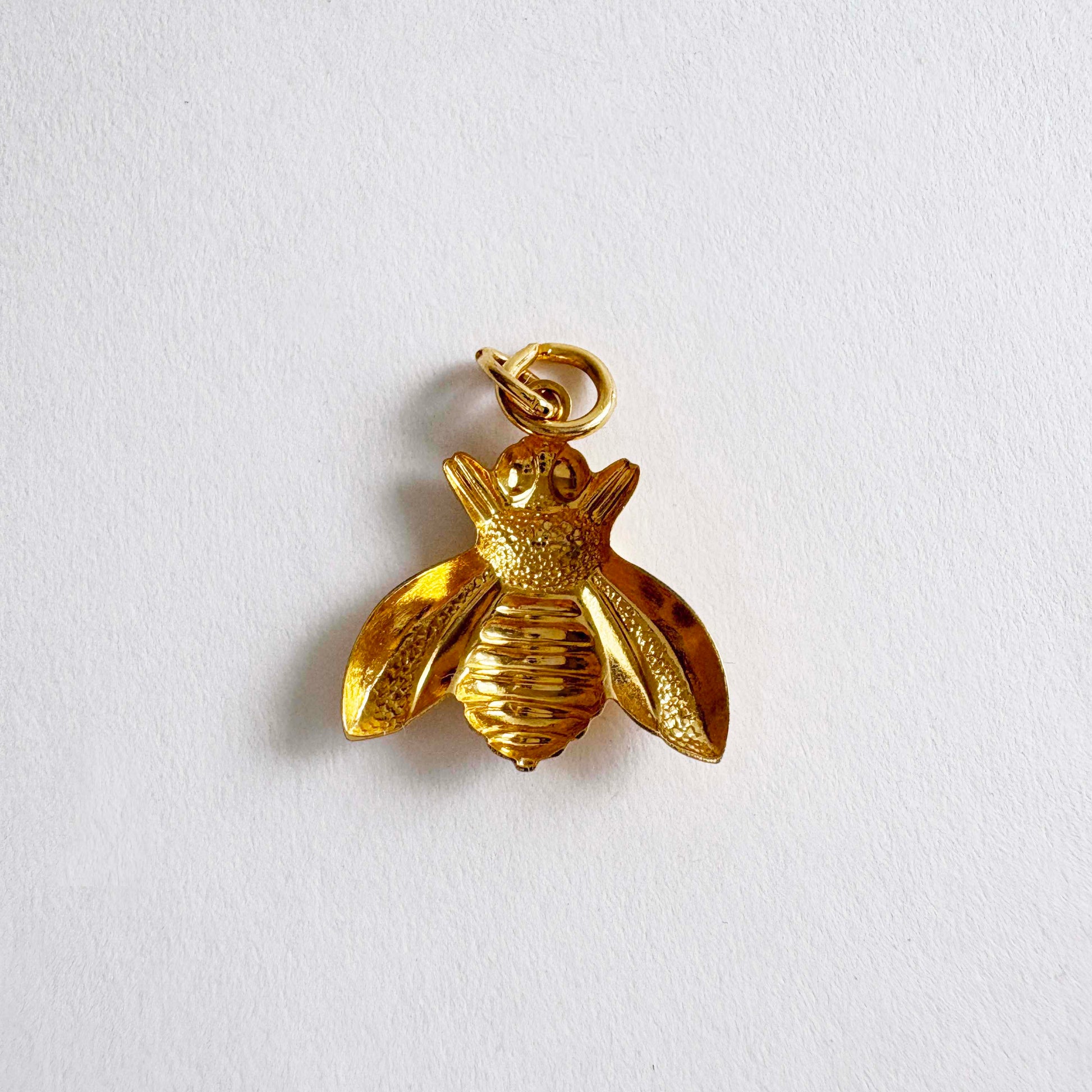 Vintage gold-tone bumble bee charm pendant with textured wings and polished body, 1980s jewelry
