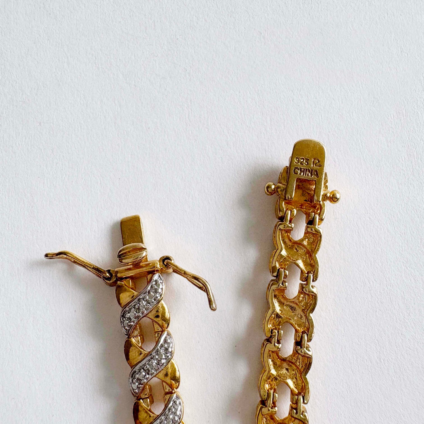Gold bracelet X-link clasp on a white background