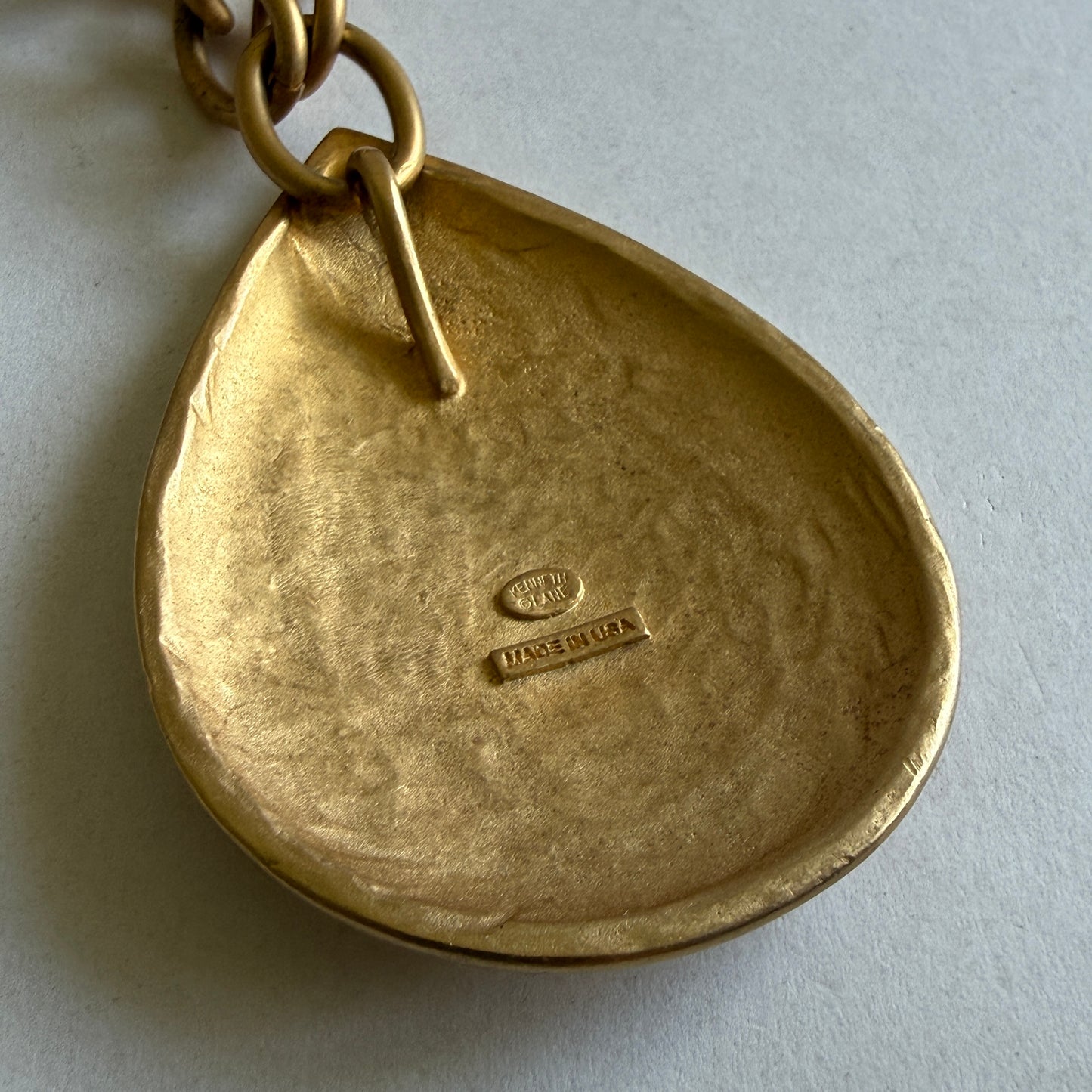 Kenneth Lane Made in USA signature vintage matte gold teardrop necklace on white gallery background