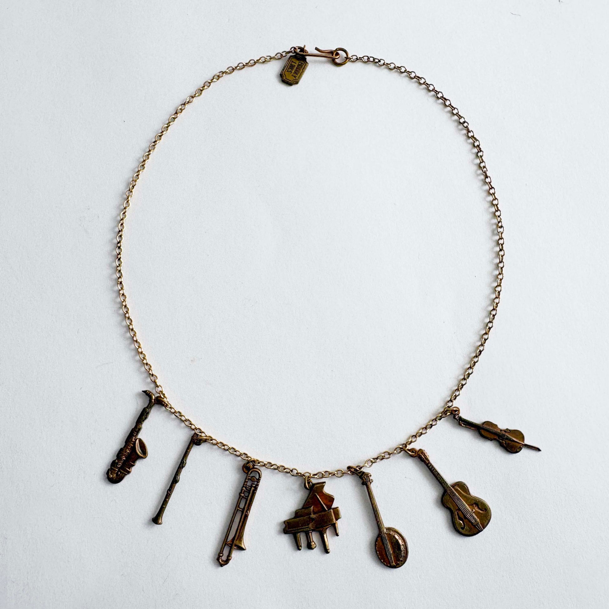 Vintage Pididdly Links brass musical instrument charm necklace with assorted instrument charms