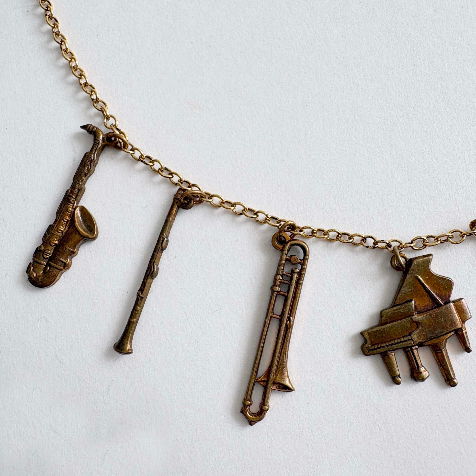Necklace with brass instrument charms on a white background