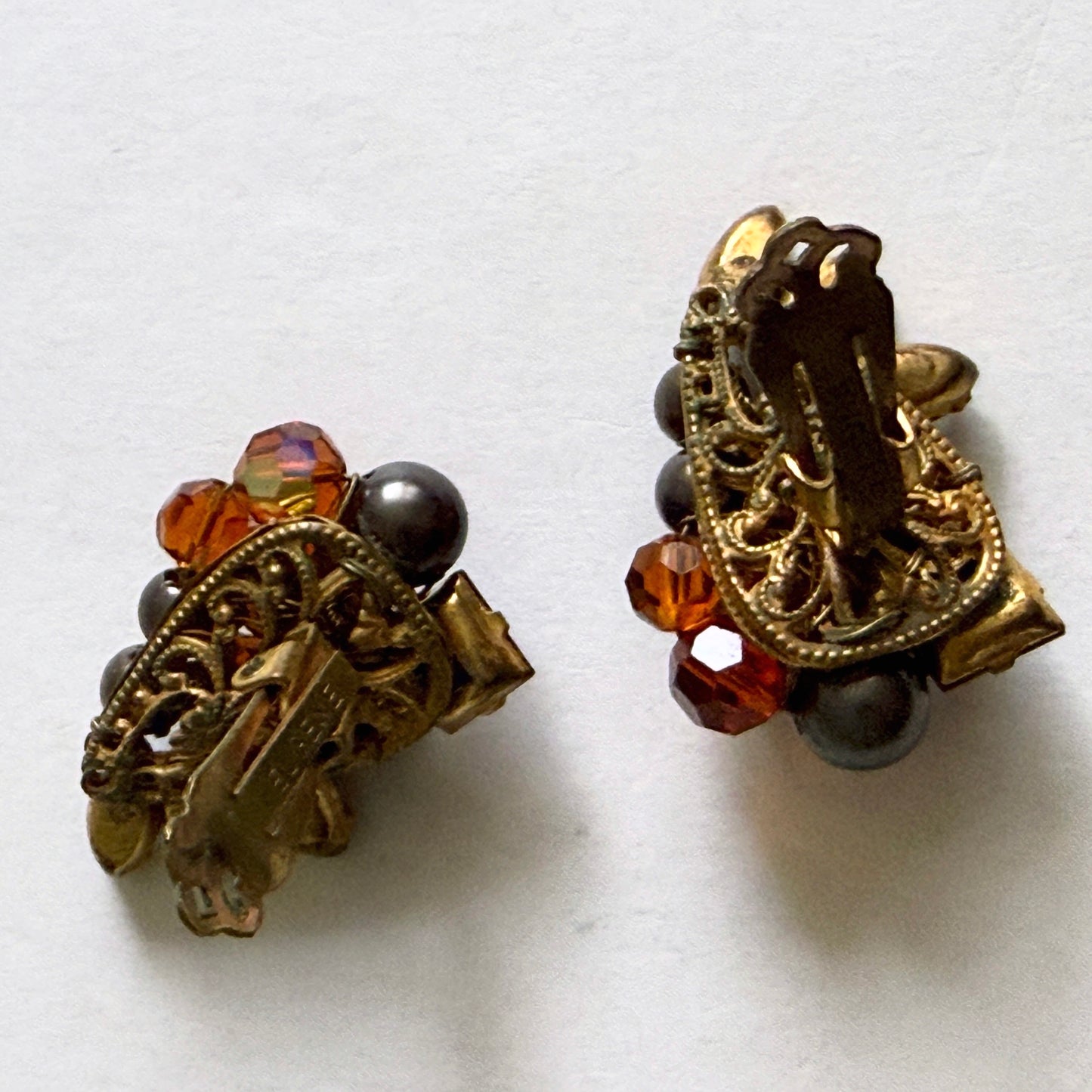 Detailed view of the reverse side of Eugene earrings showing the intricate gold-tone hand-wired filigree construction and tension clip-on mechanisms.
