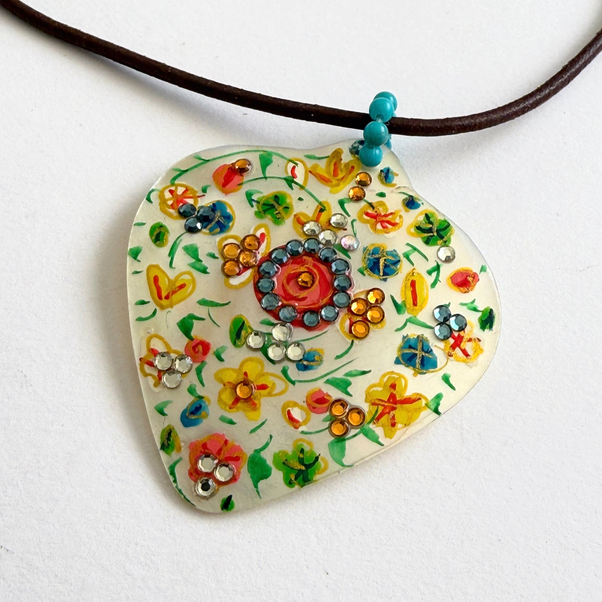 Colorful floral pendant necklace on a white background
