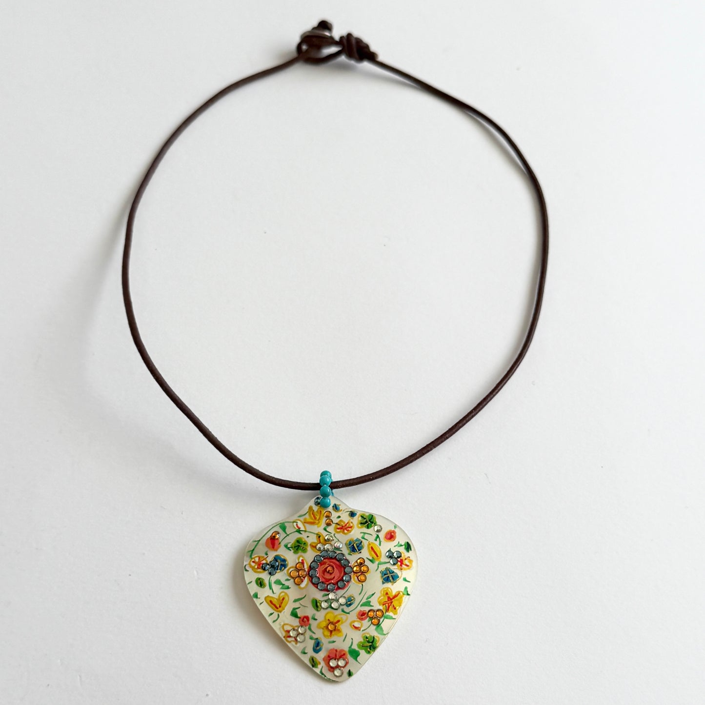 Necklace with a floral-patterned pendant on a white background