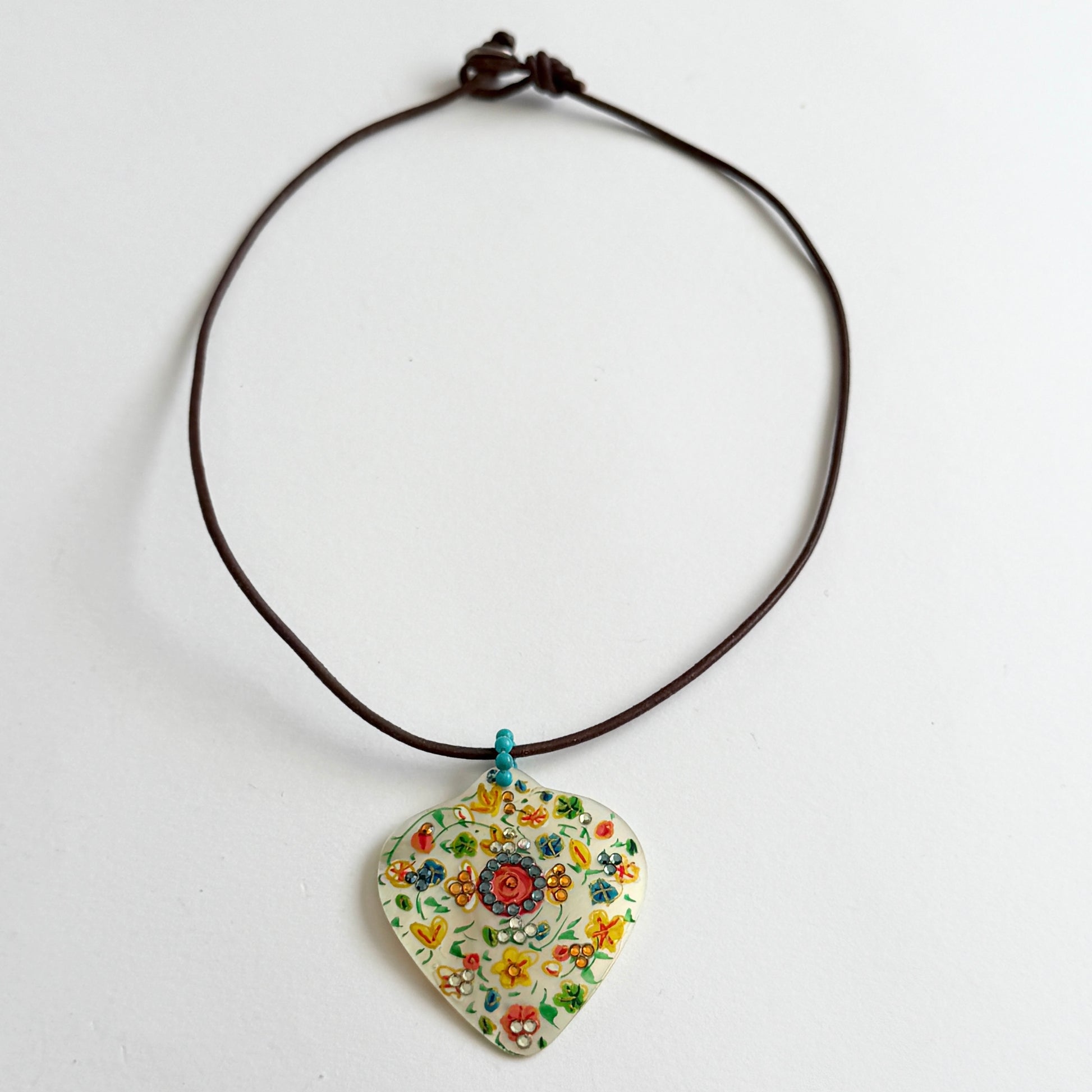 Necklace with a floral-patterned pendant on a white background