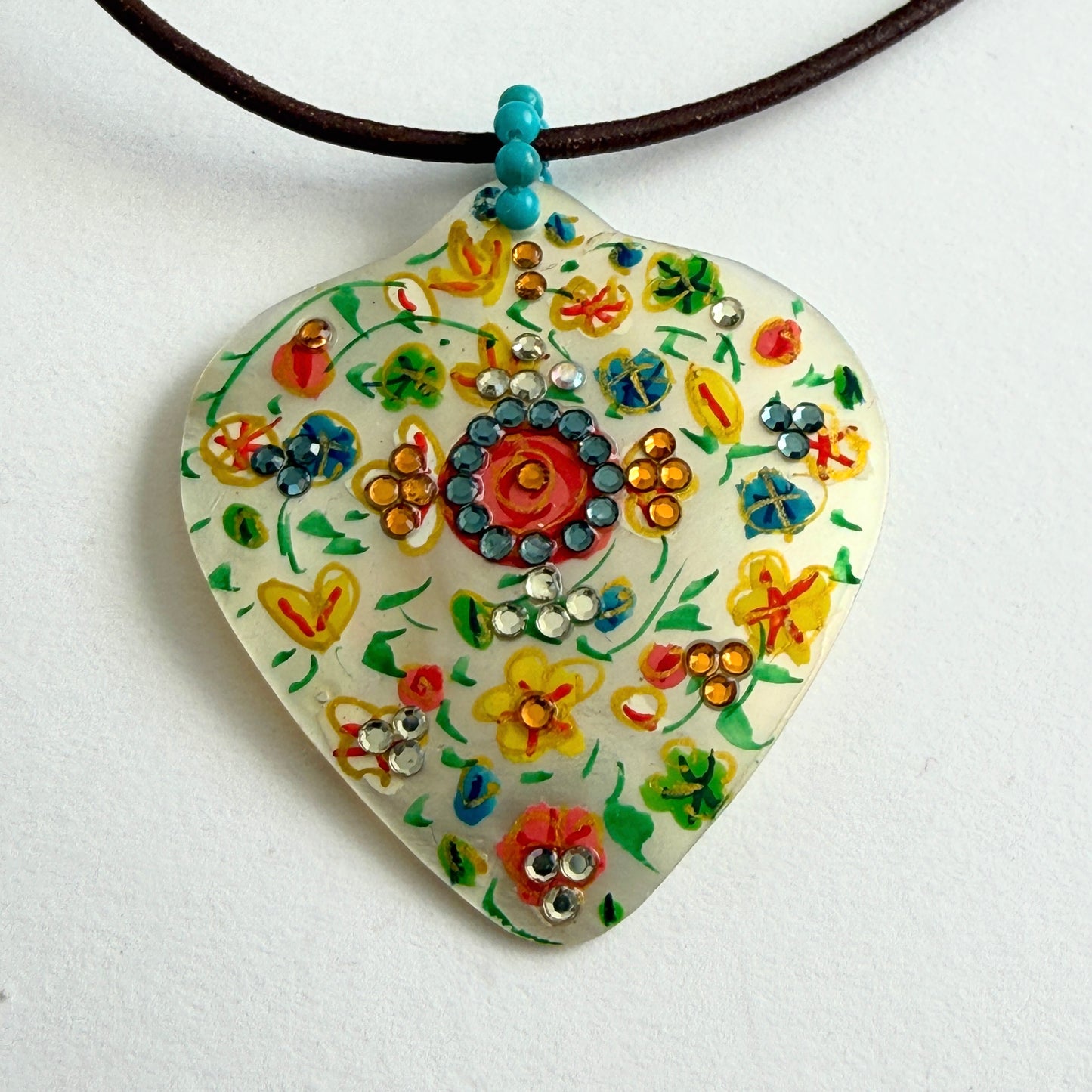Colorful floral pendant necklace on a white background