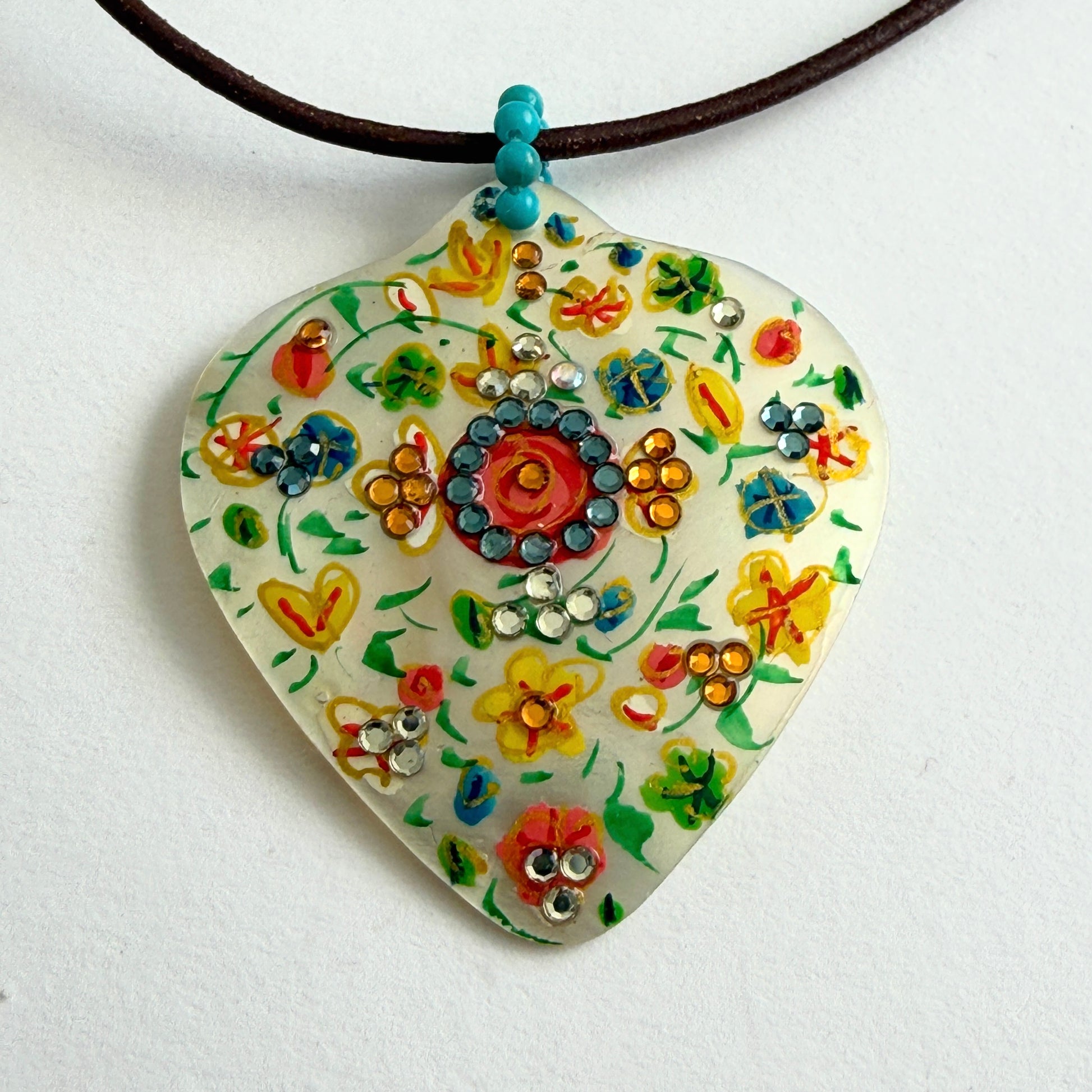 Colorful floral pendant necklace on a white background