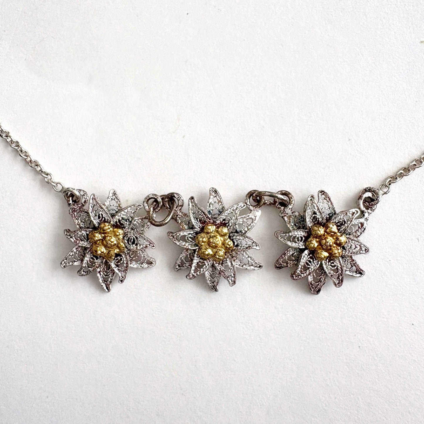 Necklace with three floral edelweiss pendants on a white background