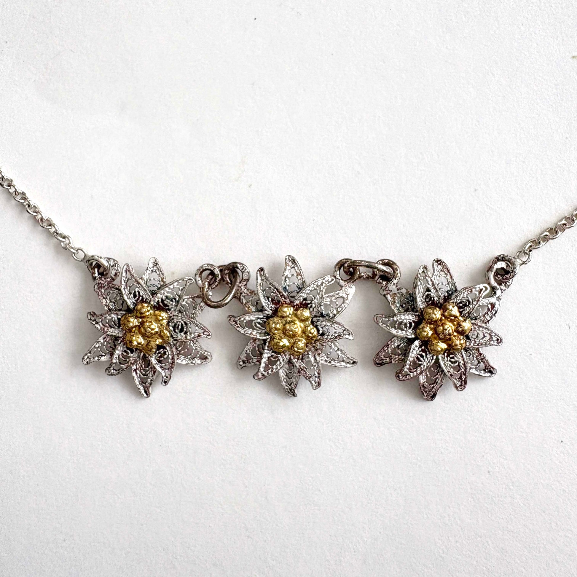 Necklace with three floral edelweiss pendants on a white background