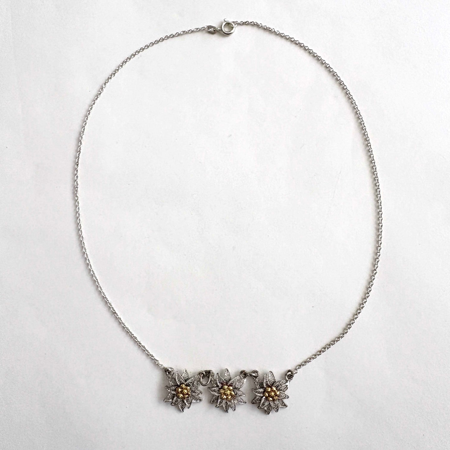 Necklace with three floral edelweiss pendants on a white background