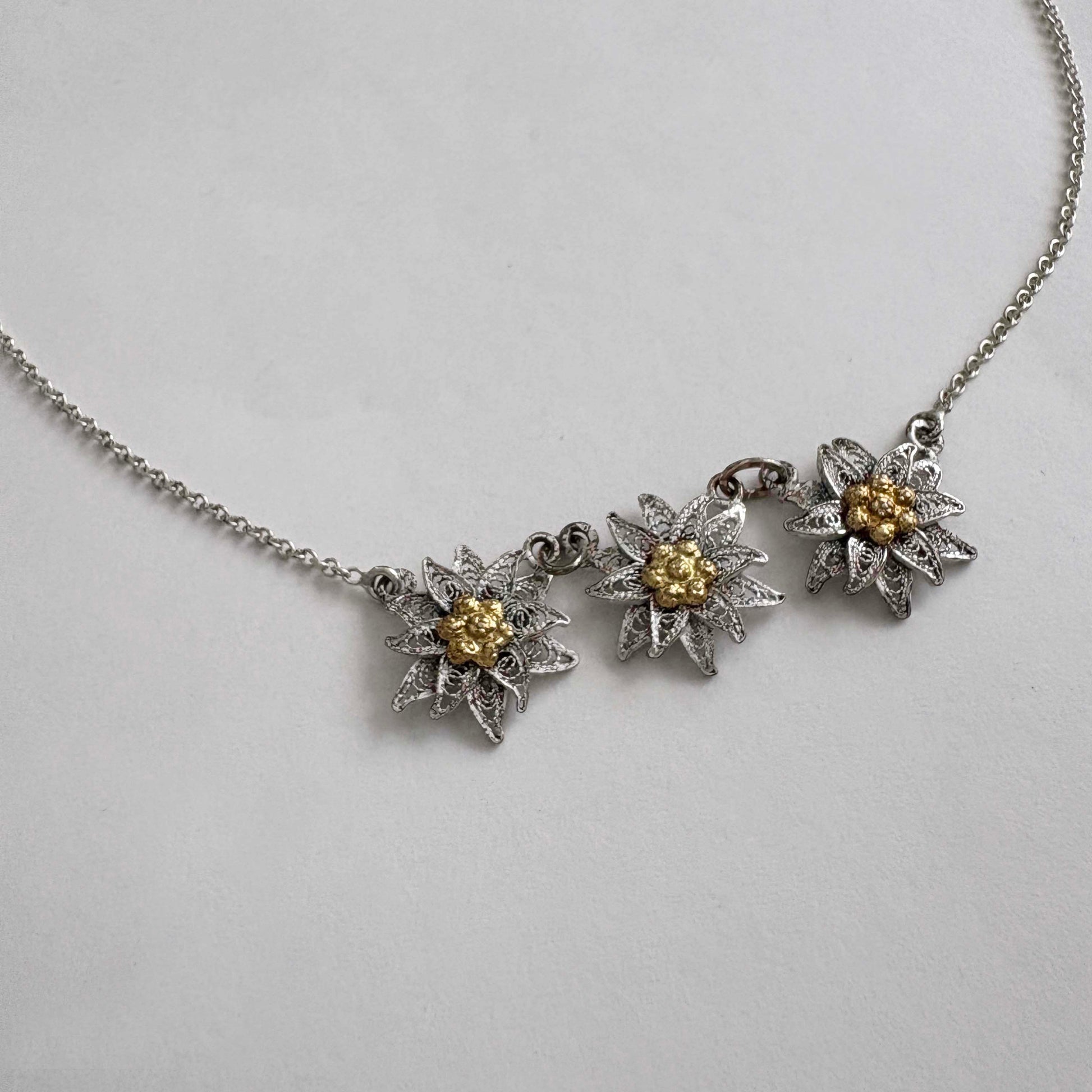 Necklace with three floral edelweiss pendants on a white background
