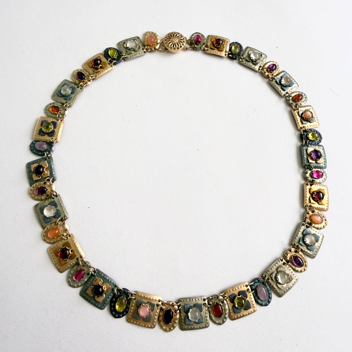 gold multicolored gemstone necklace on a white background
