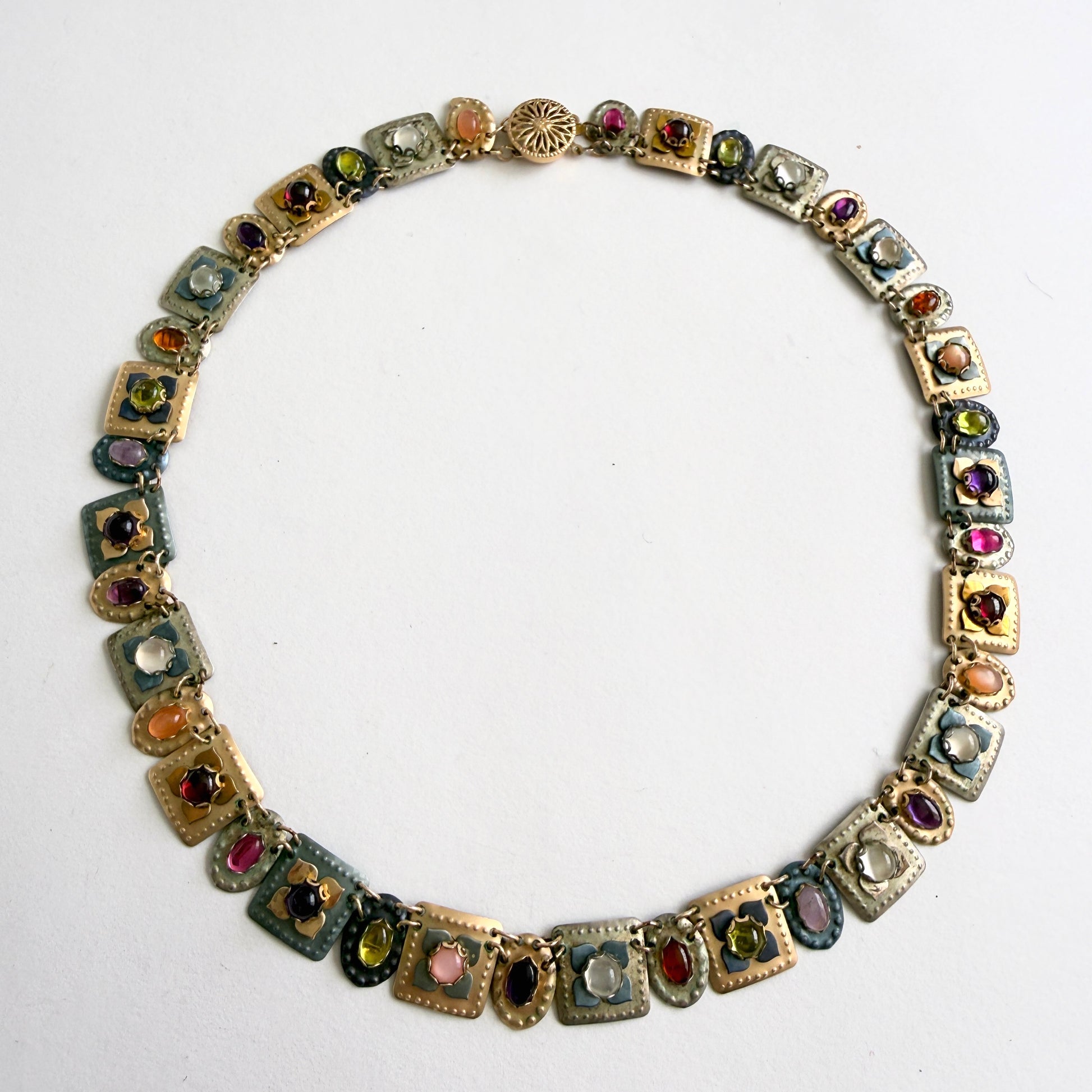 gold multicolored gemstone necklace on a white background